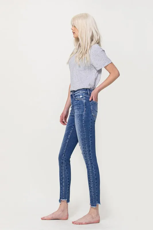 HIGH RISE ANKLE SKINNY W UNEVEN HEM DETAIL